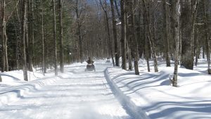 Two snowmobilers on the Northern Lights Snowmobile Club trail