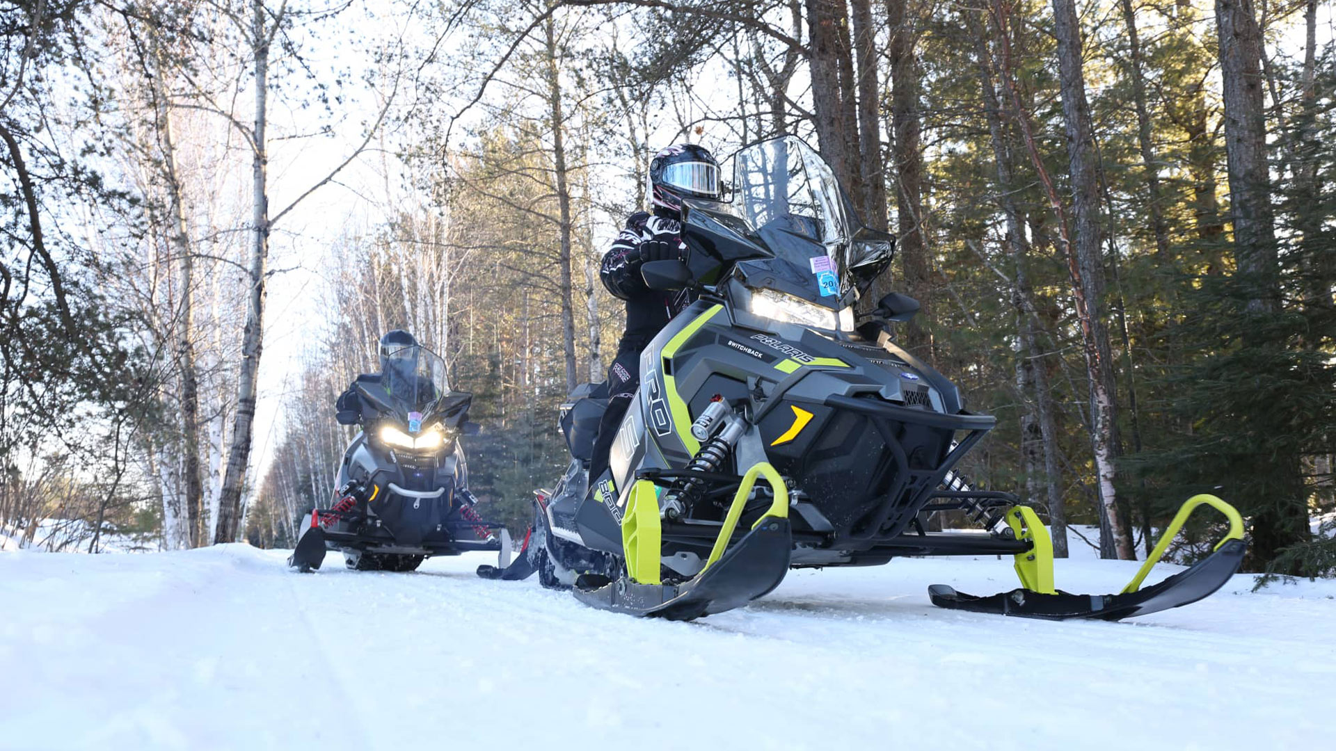 Two people riding on Oneida County’s snowmobile trails in winter northern Wisconsin