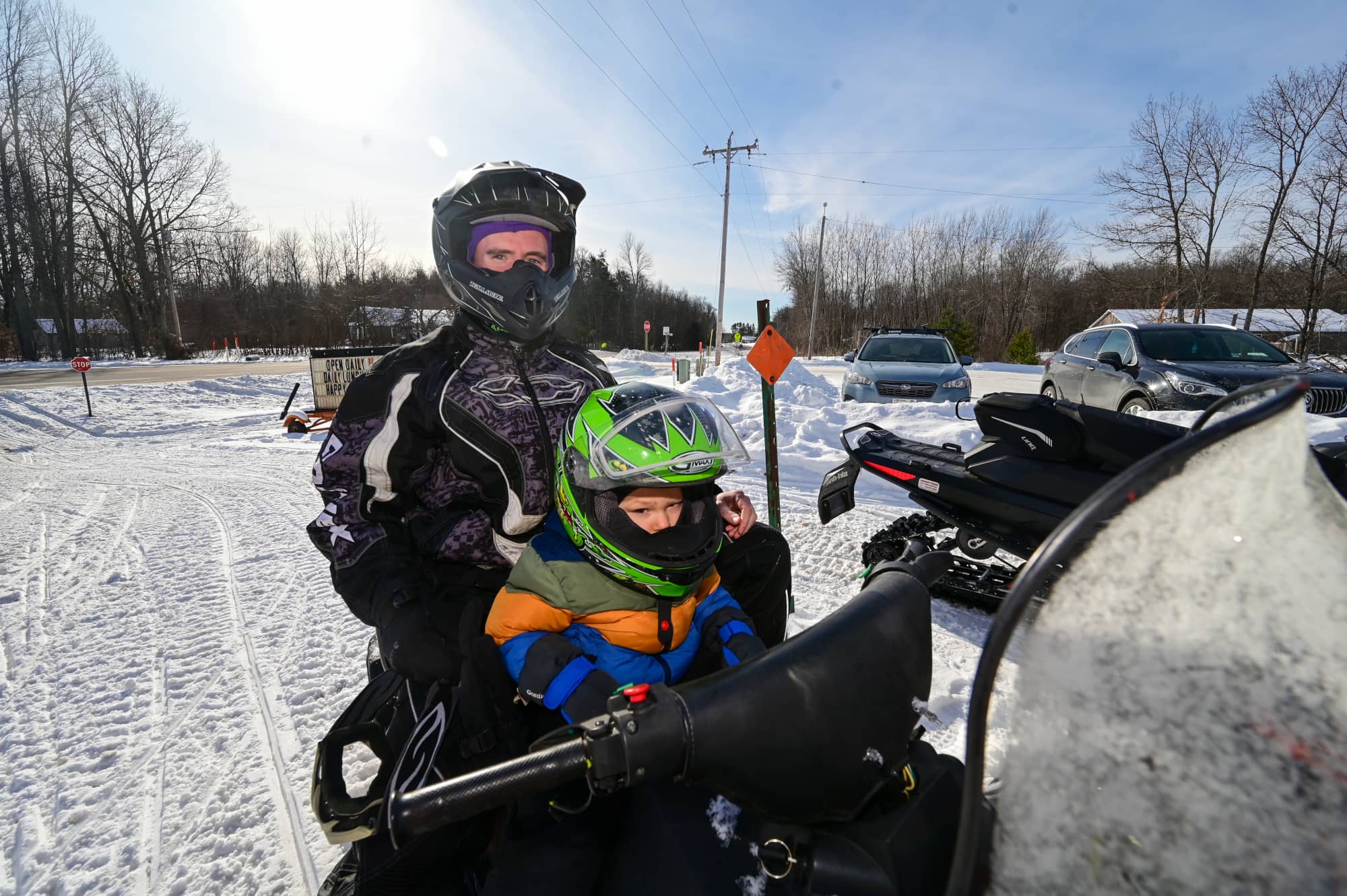 Father and son sitting on snowmobile in Oneida County Wisconsin